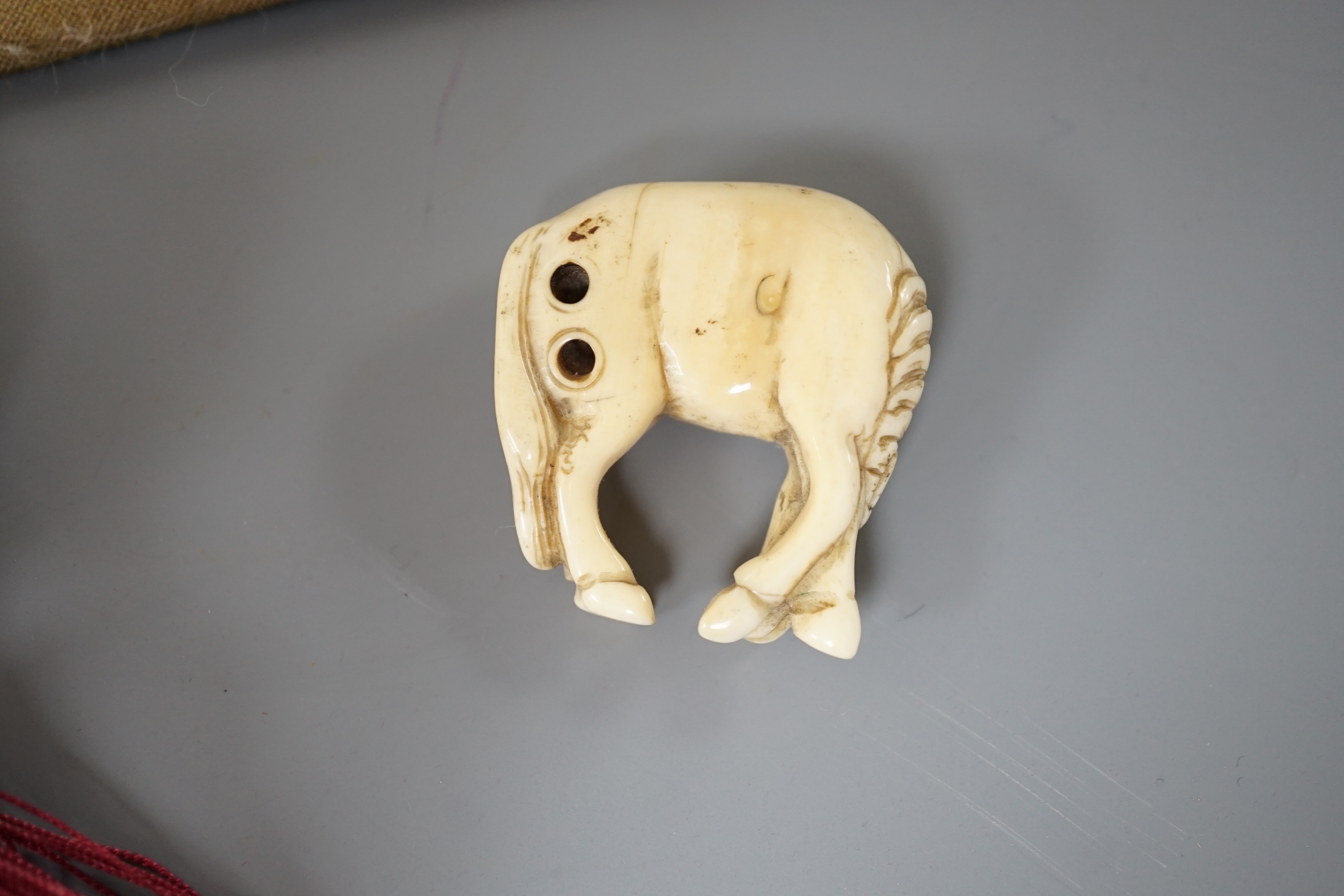 A 19th century Chinese pierced Ivory scent box together with a netsuke modelled as a horse and ivory pierced panel (3)